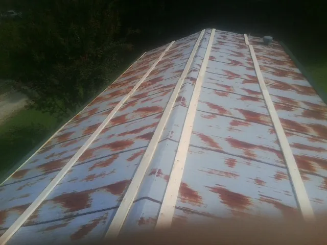 Rusted metal roof panels with new wood purlins before replacement — Storm Damage Roof Repair in Crescent by Roofing Brothers